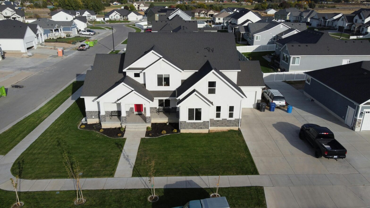 Aerial view of a white home with red door in a suburban neighborhood.
